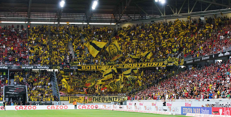 Foto von den Anhängern des BVB im Gästeblock im Freiburger Mooswaldstadion